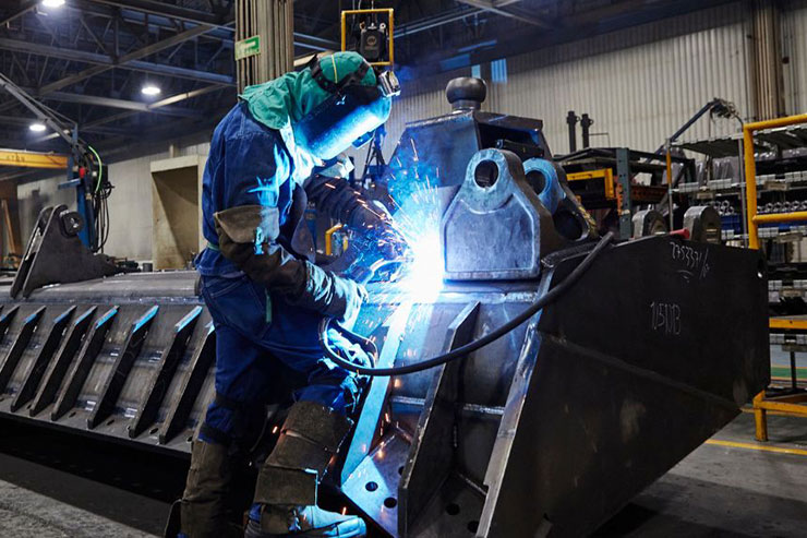 Welder is working on heavy duty bucket